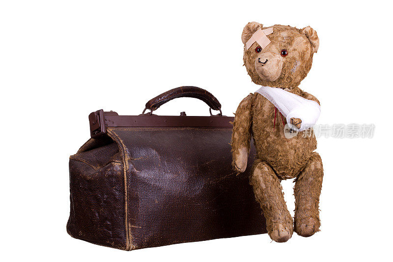 手提箱上的生病的老泰迪熊