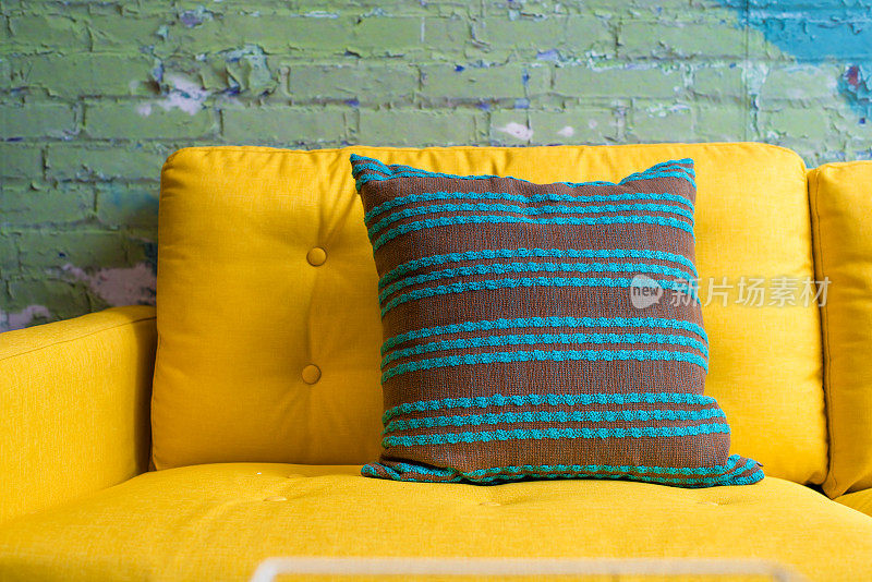 鲜黄色沙发上的绿色条纹枕头