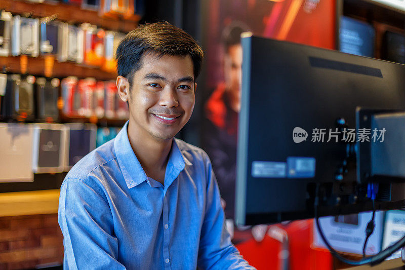 英俊的年轻亚洲男子使用电脑在办公室