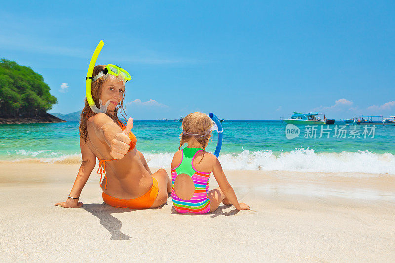 母亲和孩子在夏天的海滩度假浮潜