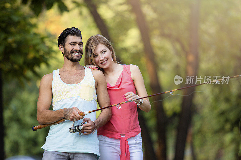 快乐的年轻夫妇钓鱼在夏天的一天