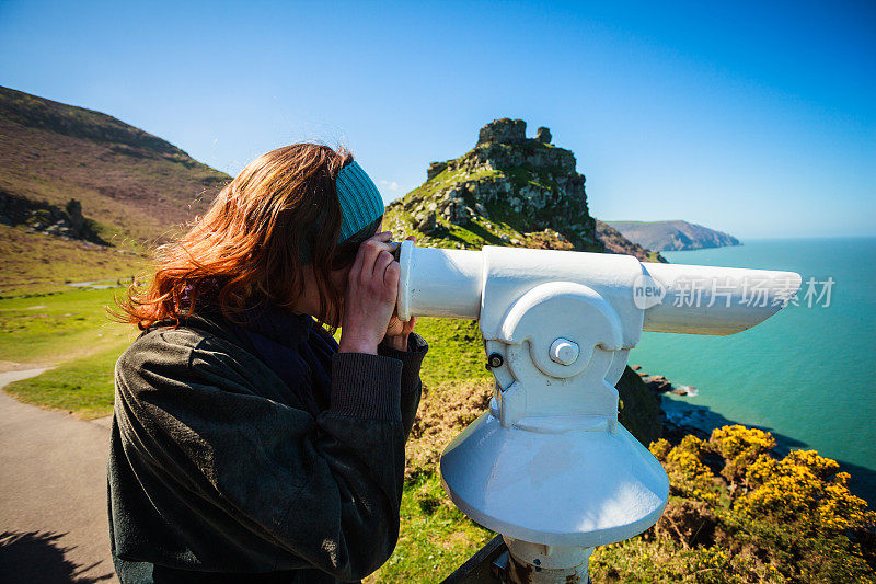 一个在海边用望远镜看东西的女人