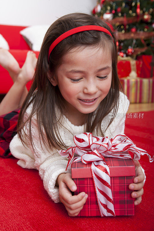 快乐的女孩低头看着圣诞礼物