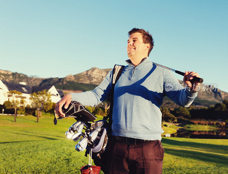 年轻的男性高尔夫球手暂停比赛享受他的周围环境