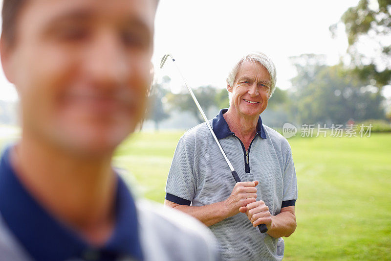 老人拿着高尔夫球棒，面带微笑