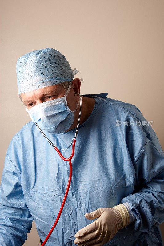 外科医生拿着听诊器，穿着无菌手术服