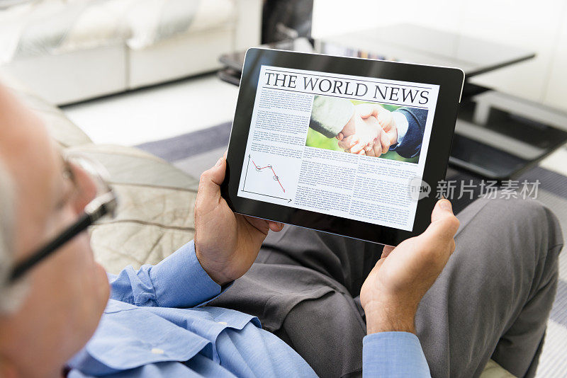 一名男子正在平板电脑上阅读《世界新闻报》