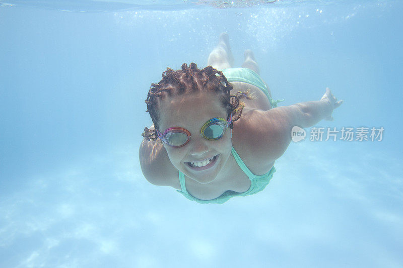 戴着护目镜在水下游泳的女孩