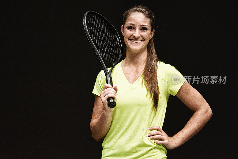 兴高采烈的女网球运动员拿着球拍
