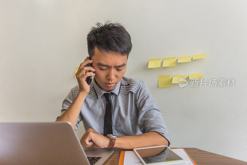 男人一边看手表一边打电话