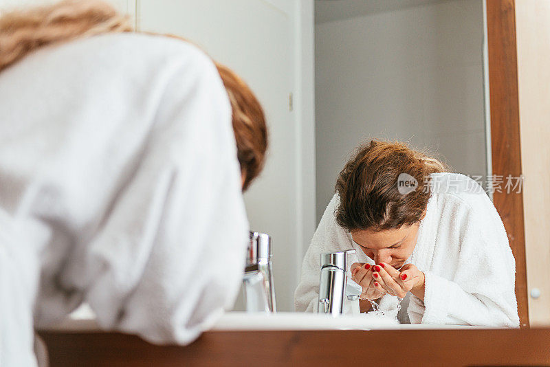 年轻开朗的女人在浴室里进行晨间卫生