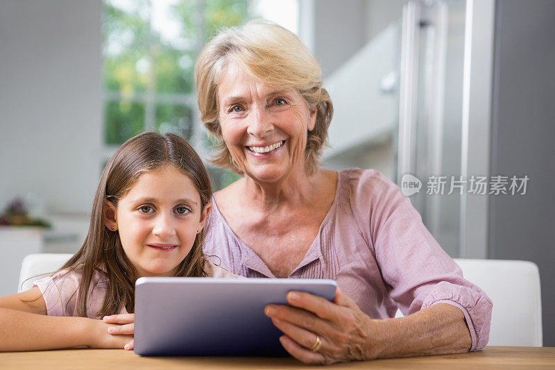 孙女和奶奶都在用平板电脑