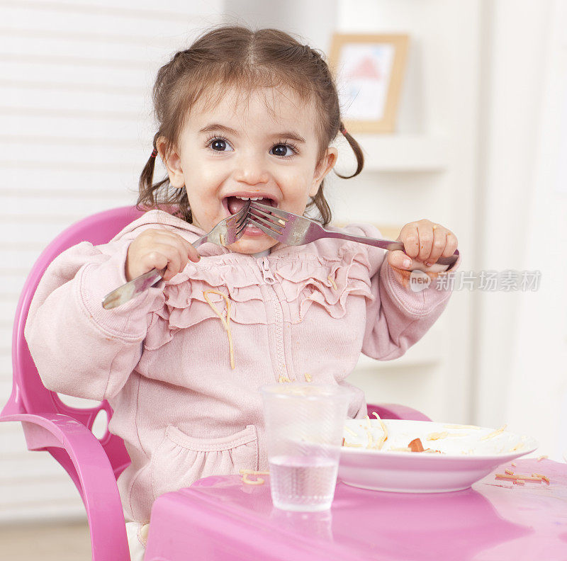 饥饿的小女孩嘴里含着两把叉子。