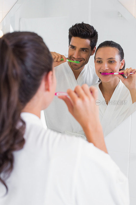 一对漂亮的夫妇在浴室镜子前刷牙