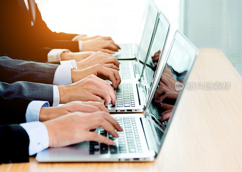 商务人士在笔记本电脑键盘上打字