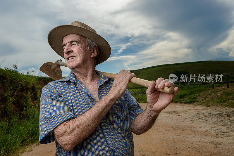 勤劳的农民拿着锄头，肮脏的道路，巴西