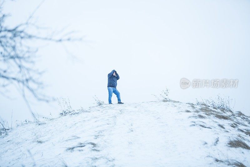 在白雪覆盖的山顶上，人类与风搏斗