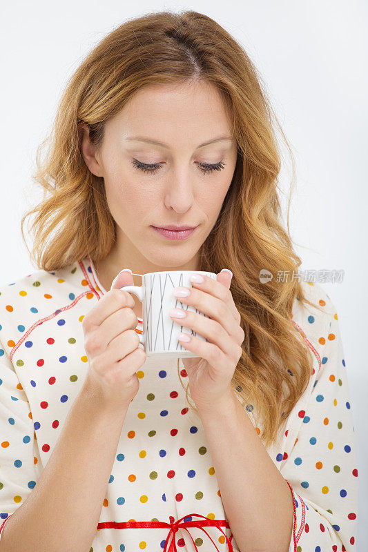 生病的女人在喝茶。