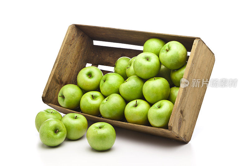 绿苹果装在木箱里，白色背景上孤立