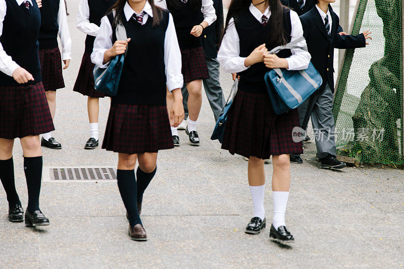 日本的高中。学校的孩子们走在外面，穿着无法辨认的校服
