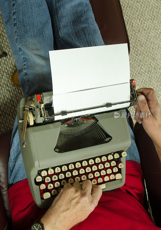 老式笔记本打字机放在男人的腿上