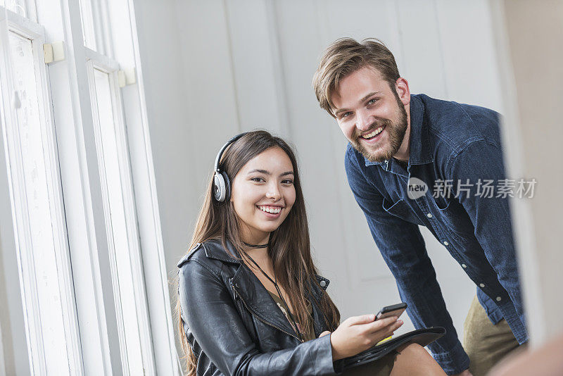 男性和西班牙裔女性带耳机和手机