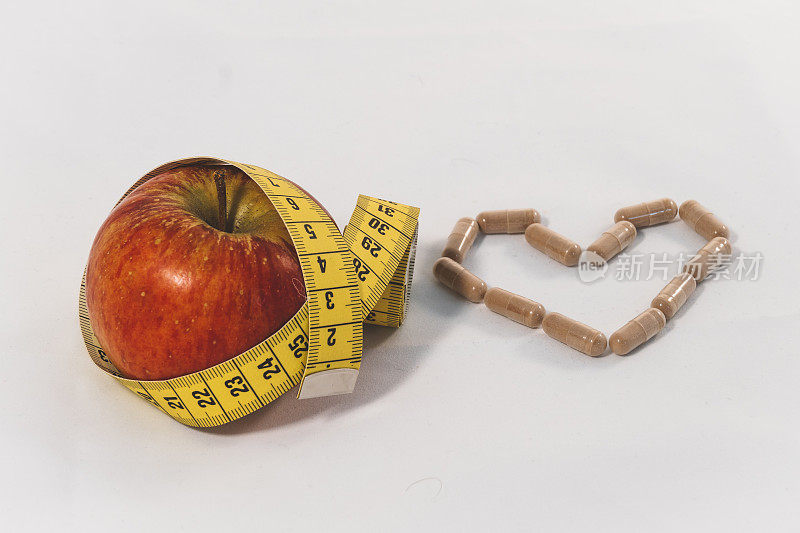 心形的营养补充剂，苹果和卷尺