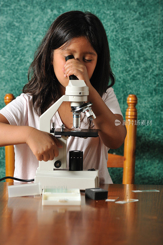 小女孩在用显微镜