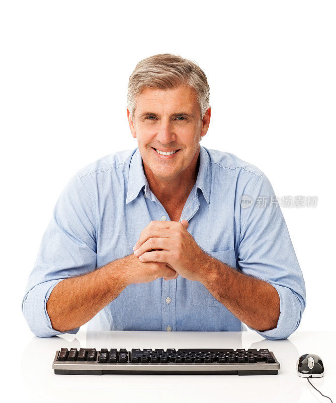 双手紧握坐在电脑桌前的男人