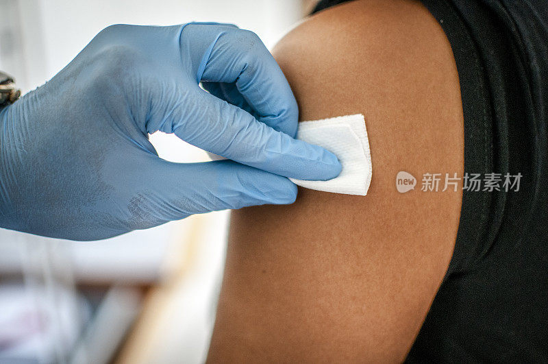 医生在接种疫苗前对病人皮肤进行消毒