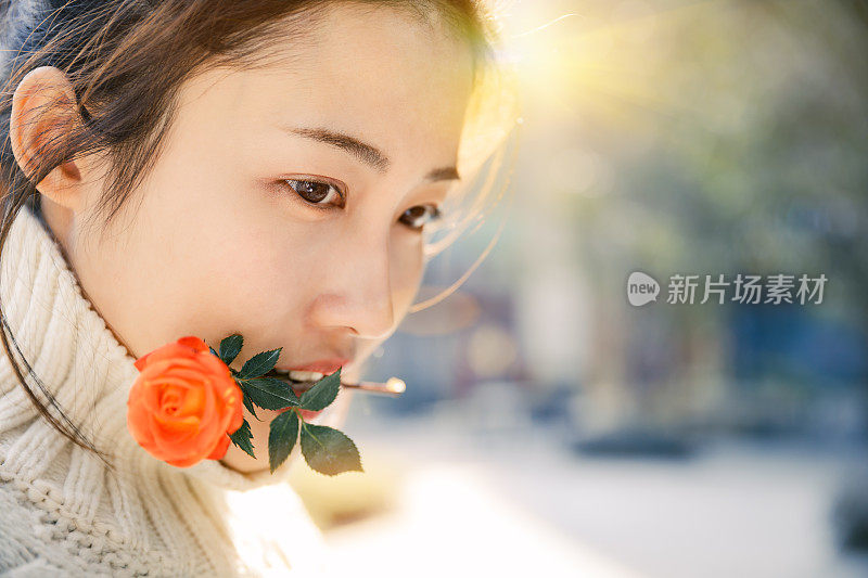 亚洲女孩在太阳耀斑下的红花，上海，中国