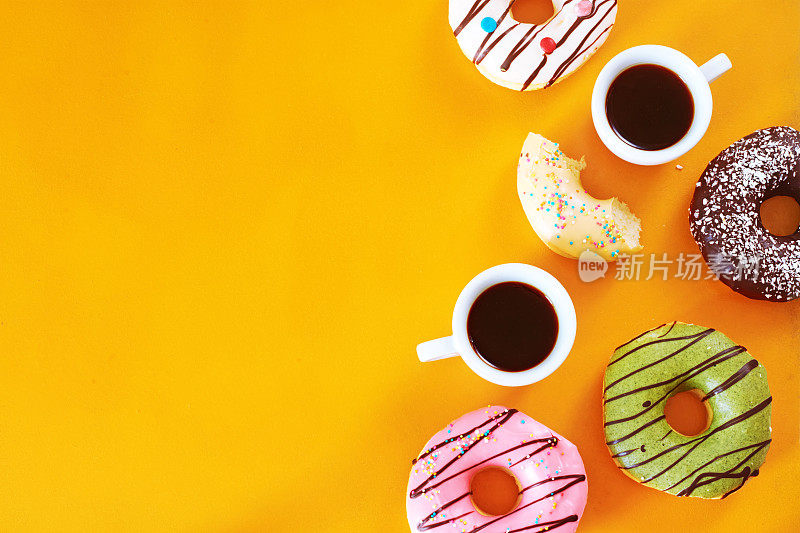 咖啡休息时间和各种甜甜圈在黄色桌子与复印空间。