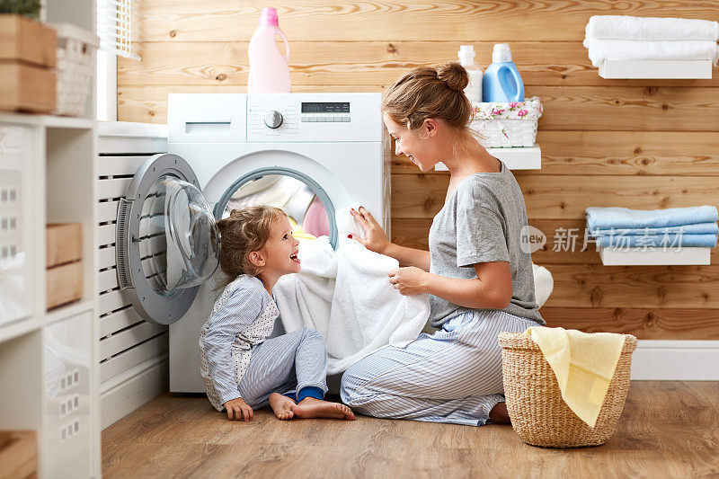 幸福的家庭，母亲，家庭主妇和孩子在洗衣机洗衣机