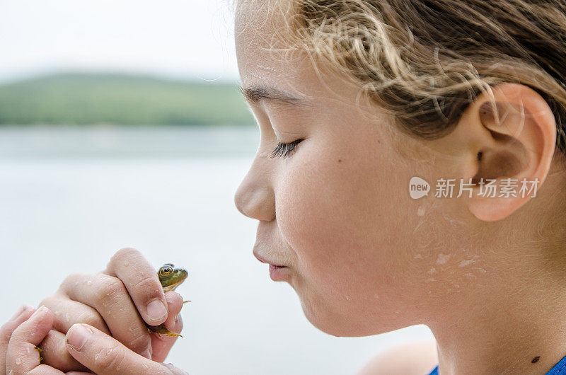 近距离小女孩准备亲吻一个真正的青蛙在户外暑假