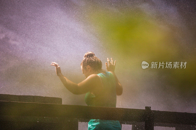 年轻女子在水花中挥挥手落下水花