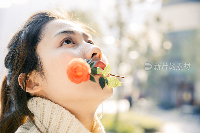 亚洲女孩在太阳耀斑下的红花，上海，中国