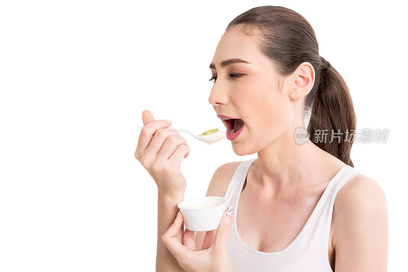 年轻女子吃酸奶孤立在白色背景