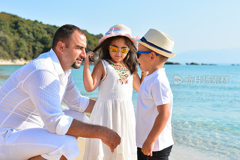 父亲带着女儿和儿子在海滩上