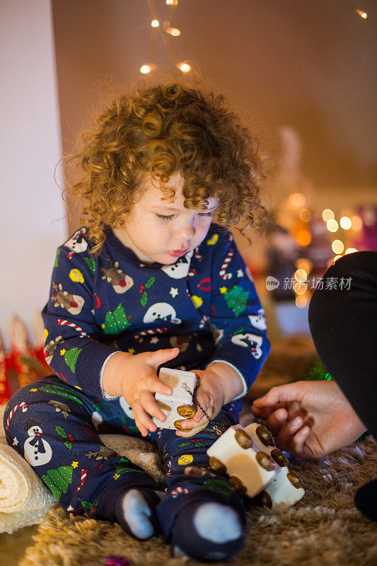 可爱的孩子在睡衣花时间与家人在室内圣诞树的背景。小男孩庆祝圣诞节和新年。