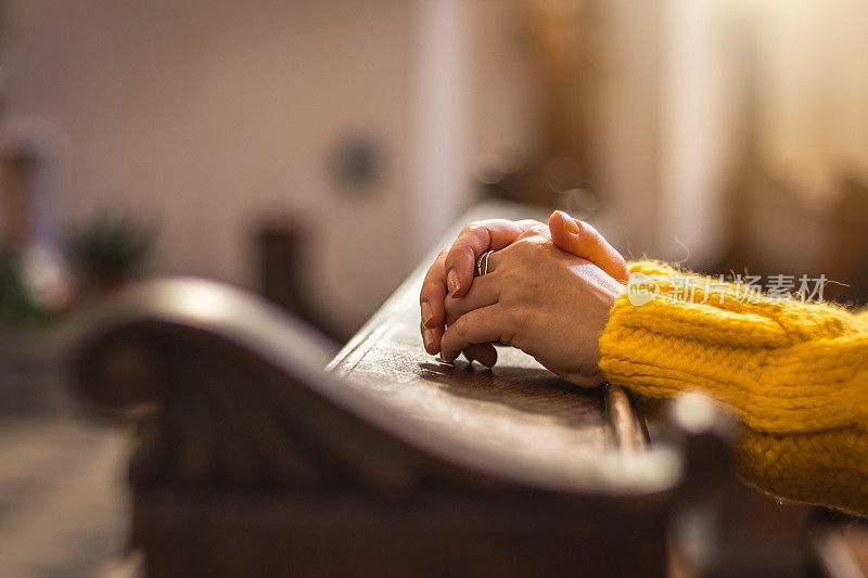 在教堂祈祷冥想时女性的手。为耶稣基督祈祷的女人。