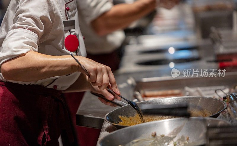 厨师用抹刀搅拌食物