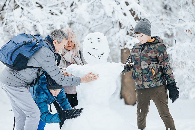 一家人在公园外面玩堆雪人