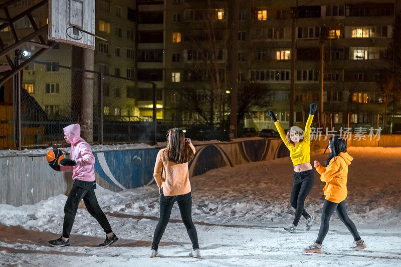 一群冬夜在户外打篮球的年轻人