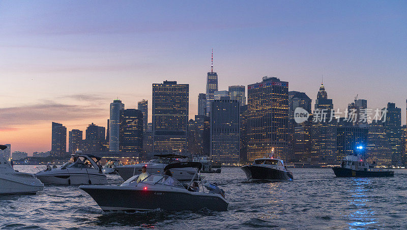 日落时分，曼哈顿市中心前的东河上有许多游艇。