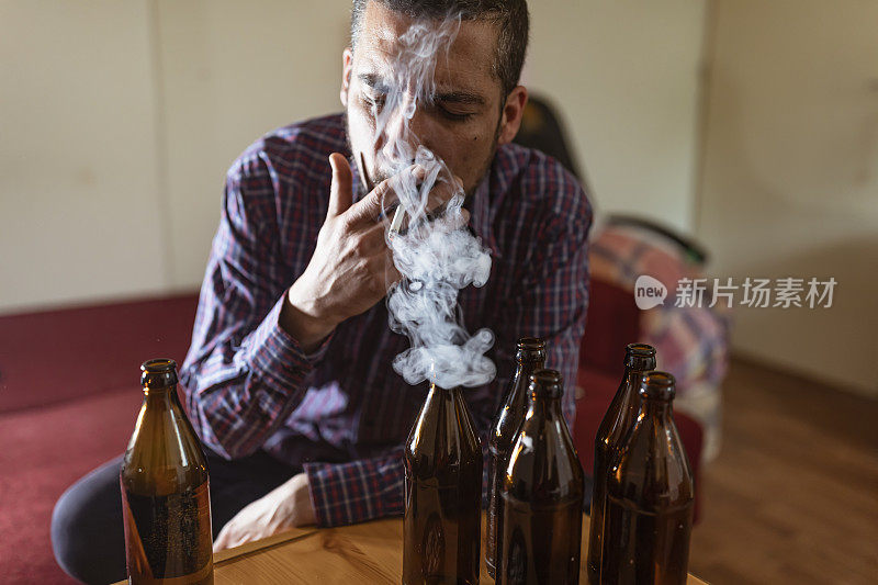 年轻悲伤的醉酒男子喝啤酒和酒精感到浪费，孤独和绝望的痛苦和情绪压力。人与酗酒、上瘾和男人抑郁的概念。