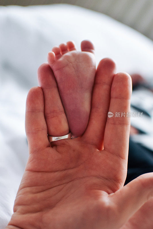婴儿的脚在妈妈的手里。妈妈和孩子