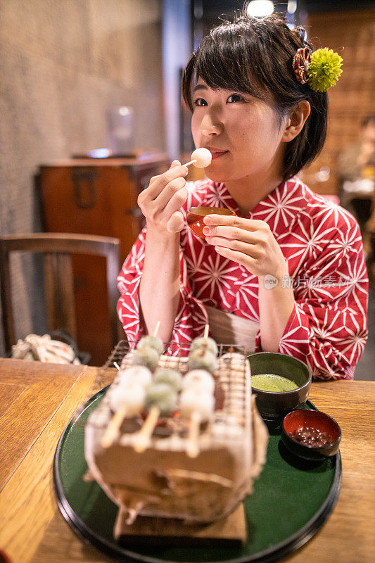 年轻女子在浴田吃日本团子饺子在传统日本餐厅