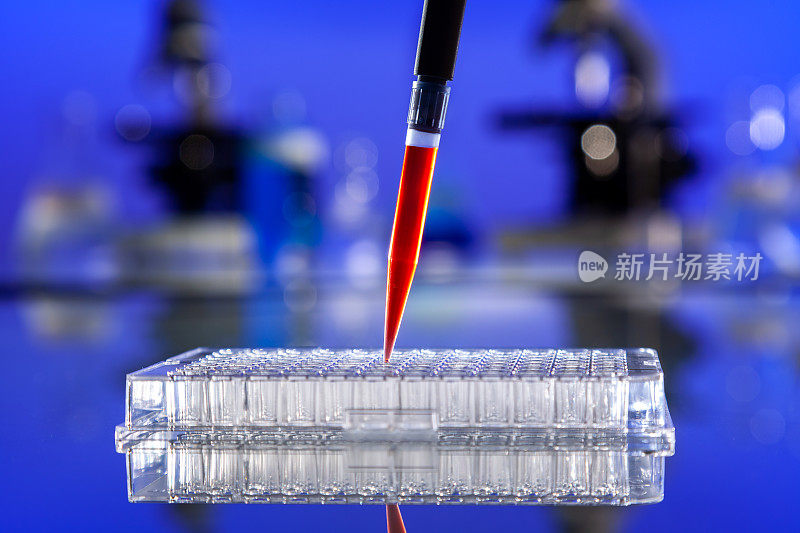 实验室血液检测或实验室检测血样或红色溶液，用移液管，96孔培养皿和显微镜