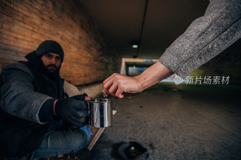 在地下通道给乞丐钱的女人