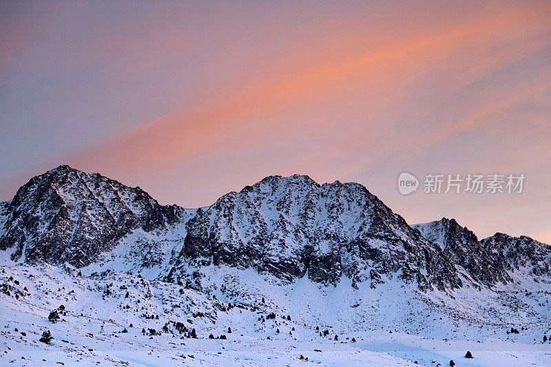 东方比利牛斯山脉白雪皑皑的山顶上的日落